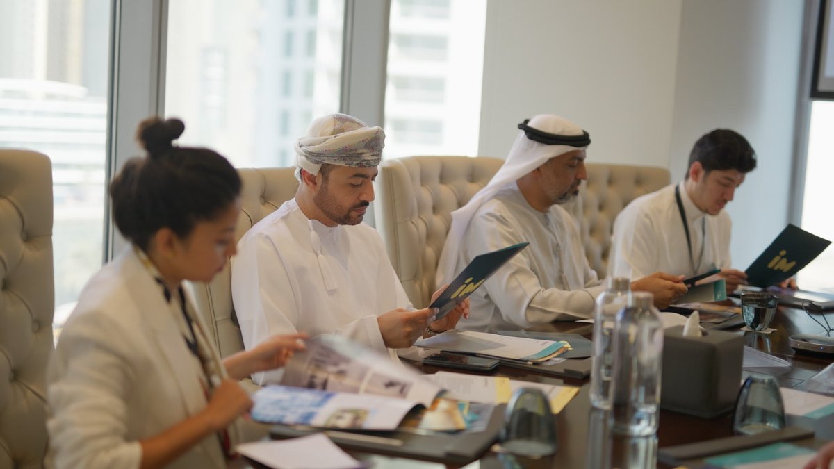 Senior executives in a Board Diploma cohort session in Dubai, working through a governance scenario around the boardroom table.